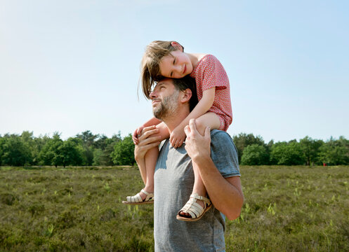 Father carrying daughter on shoulders in the Netherlands