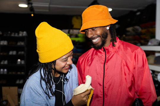 Friends laughing and eating a banana in a skate shop