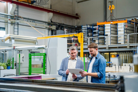 Manager and engineer planning business with tablet in factory