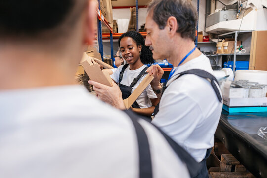 Workers communicating while packing boxes in a warehouse