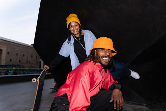 Playful friends with skateboard posing outdoors in El Raval