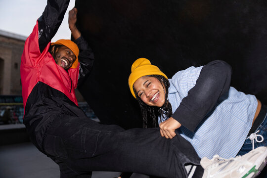 Friends laughing and playing at urban skatepark in Barcelona