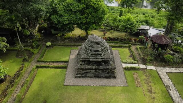 Ancient stone temple in a lush green garden. 4K high-quality heritage footage of Java, Indonesia.
