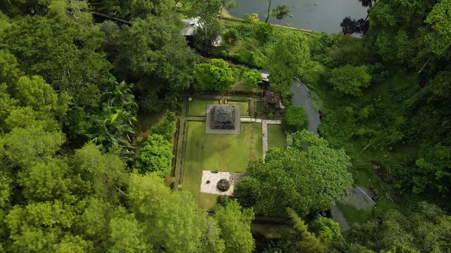 Aerial 4K view of an ancient stone temple in a lush tropical garden in Indonesia.