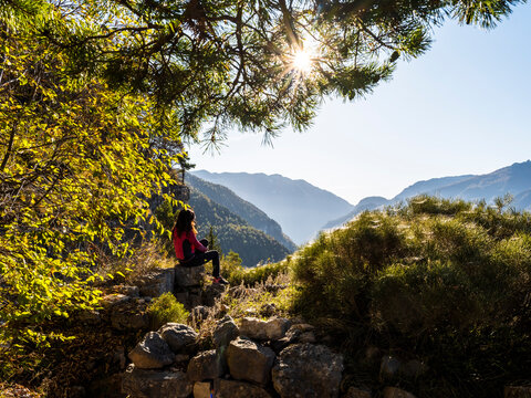 Outdoor lifestyle woman admiring autumn mountain landscape during trekking at Forra del Lupo, Great World War, Trentino, Italy. Travel and exploration.
