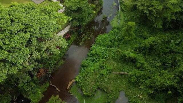 Aerial 4K view of an ancient stone temple in a lush tropical garden in Indonesia.
