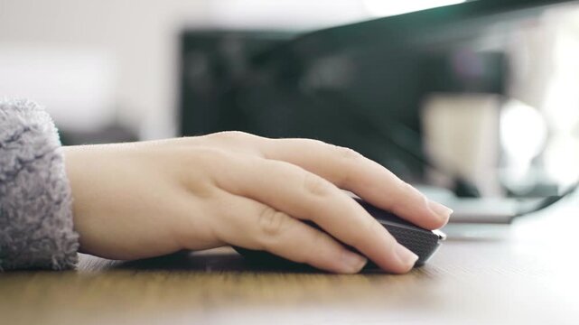 Close Up of Woman Hand Clicking Computer Mouse on Desk &ndash; Modern Workspace Concept - Female Hand Using Mouse at Office Desk &ndash; Remote Work and Technology Concept