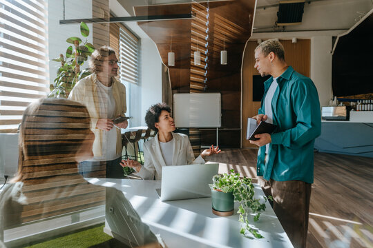 Businesspeople discussing at a desk in a modern sunny office