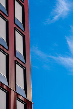 Vertical corner of a modern minimalist building frames a window against open sky using geometric architecture and strong contrast for clean exterior design