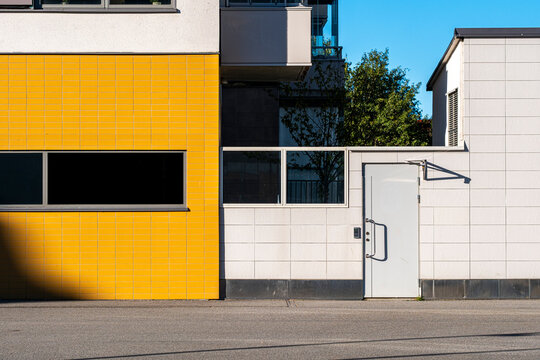Geometric entrance in color contrast tiles on a modern minimalist building facade showcasing bold architecture and clean exterior design