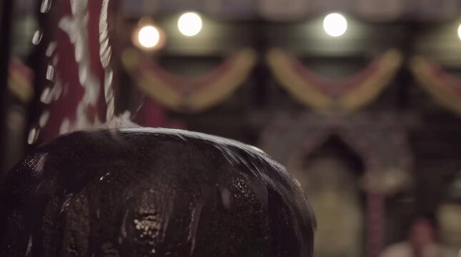 Pouring Holy Water Over Shivling for Traditional Hindu Religious Ritual