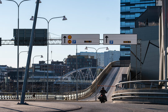 Motorcyclist on motorcycle riding road bridge in Stockholm Sweden with urban traffic in daylight depicting commuting mobility and city transport lifestyle