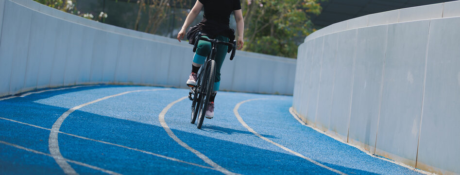 Woman riding road bike at the outdoor stadium