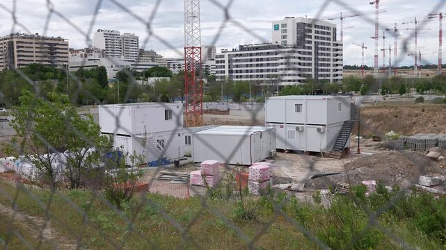 Madrid, Spain - May 4, 2026: Urban construction site with modular prefabricated offices, cranes and residential apartment buildings under development in Madrid, Spain.