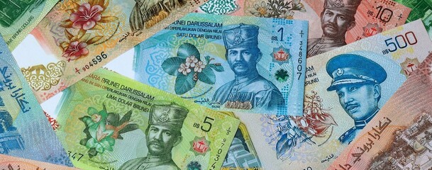 Brunei dollar money banknotes bunch on table. Brunei bills of BND currency close up © Larysa