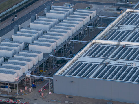 Aerial view of a hyperscale data center facility featuring rows of industrial cooling units and complex infrastructure.