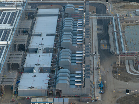 Aerial view of a hyperscale data center facility featuring rows of cooling units and industrial infrastructure.