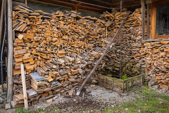 A neatly stacked woodpile of birch firewood outside the building