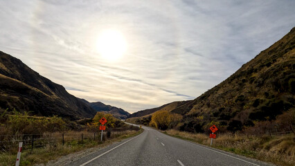 Fototapeta premium Winding Mountain Road Under Bright Sun in Queenstown New Zealand