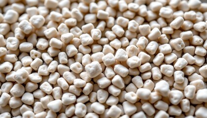 Fototapeta premium The image is a close up photograph of spherical grains, which appear to be uncooked popcorn, densely packed together in a way that creates a patterned texture.