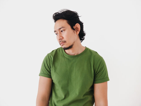 Bored and depressed burnout Asian man in green t-shirt isolated on white.