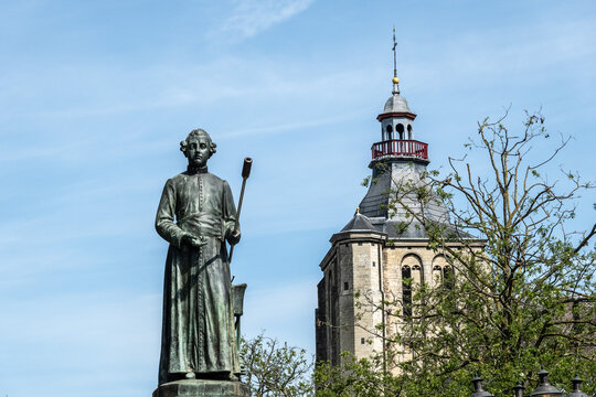 Standbeeld van Minckeleers mit Kirche im Hintergrund in Maastricht, Limburg, Niederlande