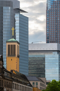 Historic church contrasts with corporate skyscrapers in Frankfurt Bankenviertel Germany where banking and finance shape the modern business district skyline
