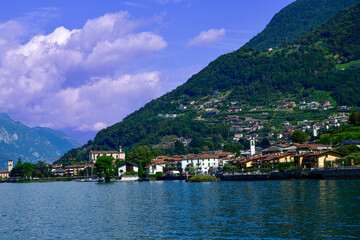 Fototapeta premium Blick über den Iseosee auf die Küstenstadt Marone mit der Kirche San Martino vor Berghängen, Italien