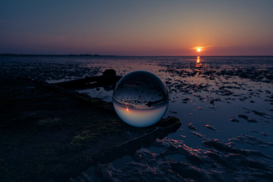 Glass Sphere on Shipwreck at Sunset Wadden Sea Refraction