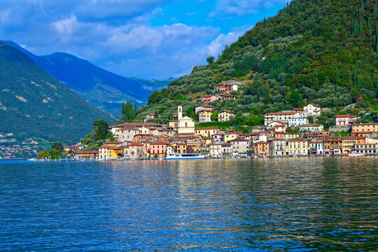 Blick vom Wasser auf das malerische Fischerdorf Peschiera Maraglio an den H&auml;ngen der Monte Isola im Iseosee, Italien