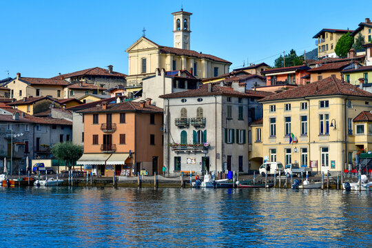 Blick vom Wasser auf die Pfarrkirche San Michele Arcangelo und die bunte H&auml;userfront in Peschiera Maraglio auf der Monte Isola, Iseosee