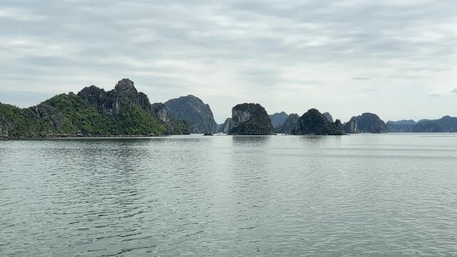 scenic panoramic view of limestone karst islands in halong bay vietnam with calm turquoise waters and cloudy sky