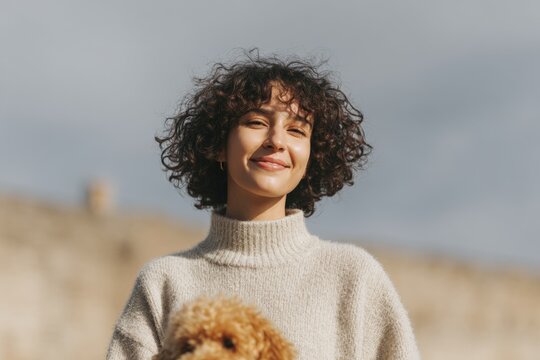 A woman with a warm smile on her face holding a teddy bear in her arms. the background is slightly blurred giving the a dreamy feel.
