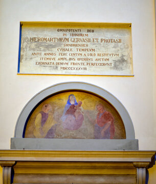 Lateinische Inschrift und religi&ouml;ses Fresko &uuml;ber dem Portal der Collegiata ss Gervasio e Protasio in Sondrio, Italien 