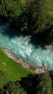 Vertical drone descending toward turquoise Dora Baltea river with strong alpine currents