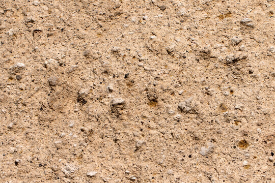 Close-up of fairy chimney tuff shows compacted ash and lapilli, a porous, easily eroded surface, and high workability, explaining both rapid shaping by weather and its suitability for rock-carved dwel