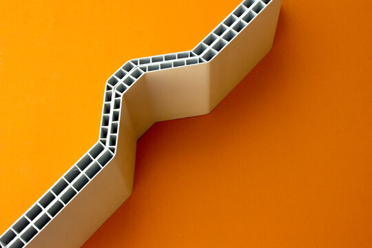 A background made from a close-up photo of a white UPVC roof on an orange background.