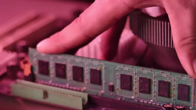Technician Hand Installing DDR RAM Memory Module into Motherboard Slot for Computer Hardware Upgrade