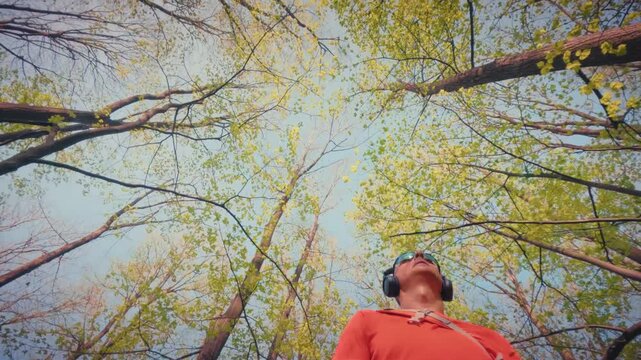 A fit mature man in his 50s resting and looking up after exercise. Concept of physical vitality, recovery, and enjoying nature after fitness. 4k resolution.