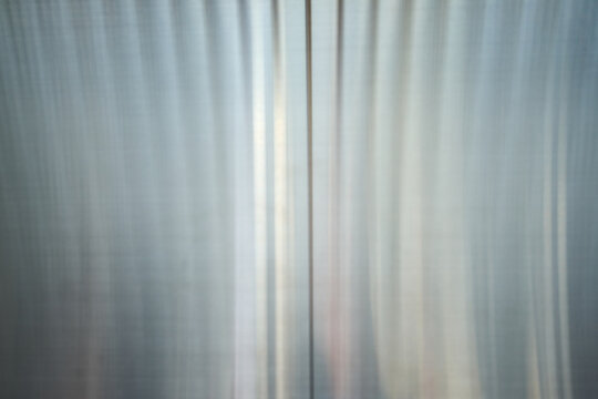 Close-up of dark polished metal surface with light gradients and industrial texture for background use.