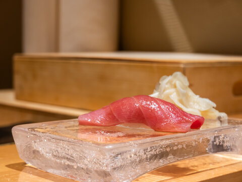 Premium otoro nigiri sushi served on ice plate in Japanese restaurant, close up of fatty tuna sashimi on rice with pickled ginger, luxury fine dining seafood delicacy, fresh gourmet cuisine concept