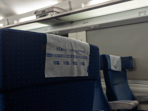 Khmelnytskyi, Ukraine - March 30, 2026: Ukrzaliznytsia logo and slogan on a headrest cover inside a passenger train carriage, highlighting national rail transport service details