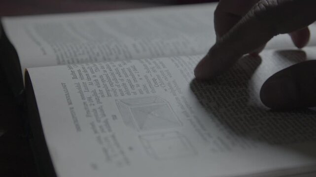 A detailed shot of flipping pages in an aged book, showcasing education, reading habits.