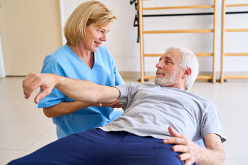 Obraz premium Senior Man Receiving Arm Physiotherapy From Female Therapist In Rehab Center Indoor Rehabilitation Exercise For Recovery And Mobility