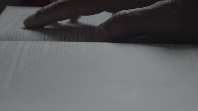 A close-up of hands flipping through old book pages, highlighting reading, education, and the nostalgic texture of printed paper.