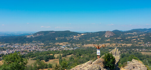 woman standing on rock enjoying panoramic valley view, freedom, inspiration and achievement concept