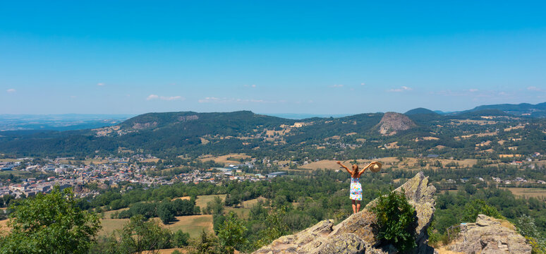 woman standing on rock enjoying panoramic valley view, freedom, inspiration and achievement concept