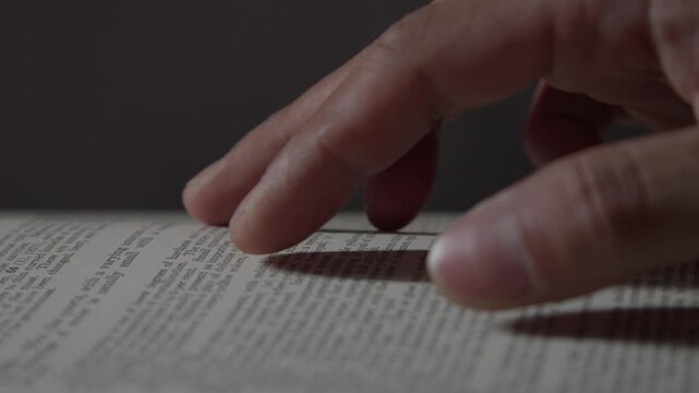 A close-up of flipping book pages, capturing the tactile motion of reading and education with a nostalgic feel of browsing through an old book.