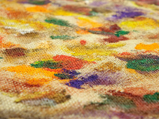 Fototapeta premium Various multi-colored spots of different shapes from paint brushes with gouache and acrylic paint on the beige burlap fabric, abstract background