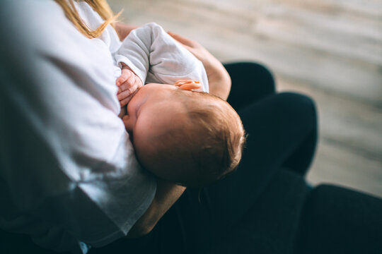 Portrait of a newborn baby. Mother holds a child in her arms. The first year of life. Care and care.